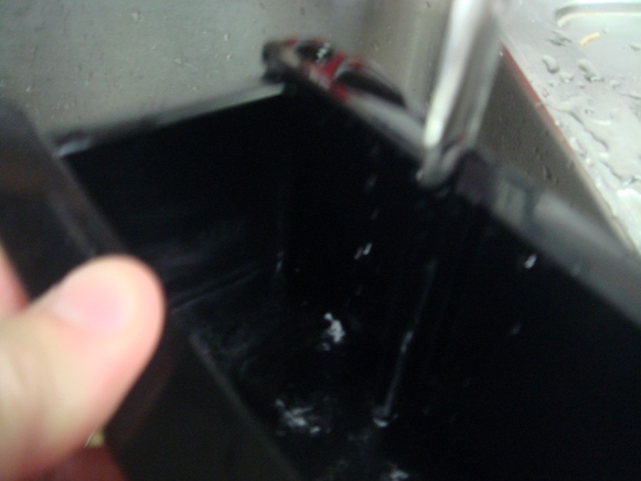 製氷器に水を注ぐ